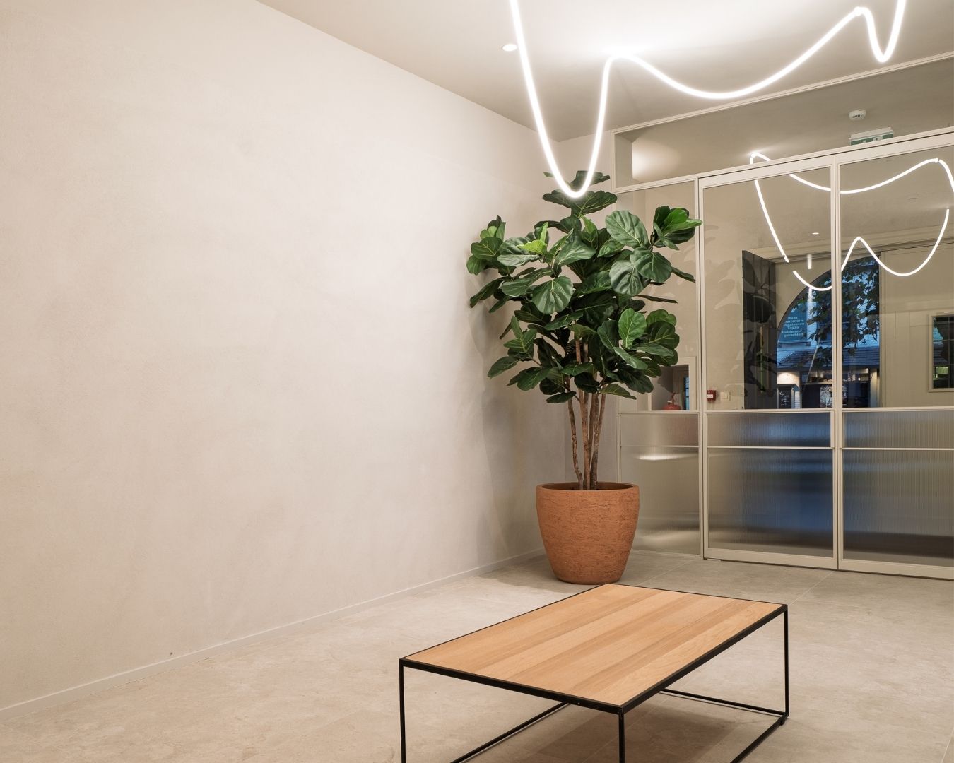 Inkomhal van 2Besure met glazen scheidingswand en decoratieve wandafwerking van Tintology